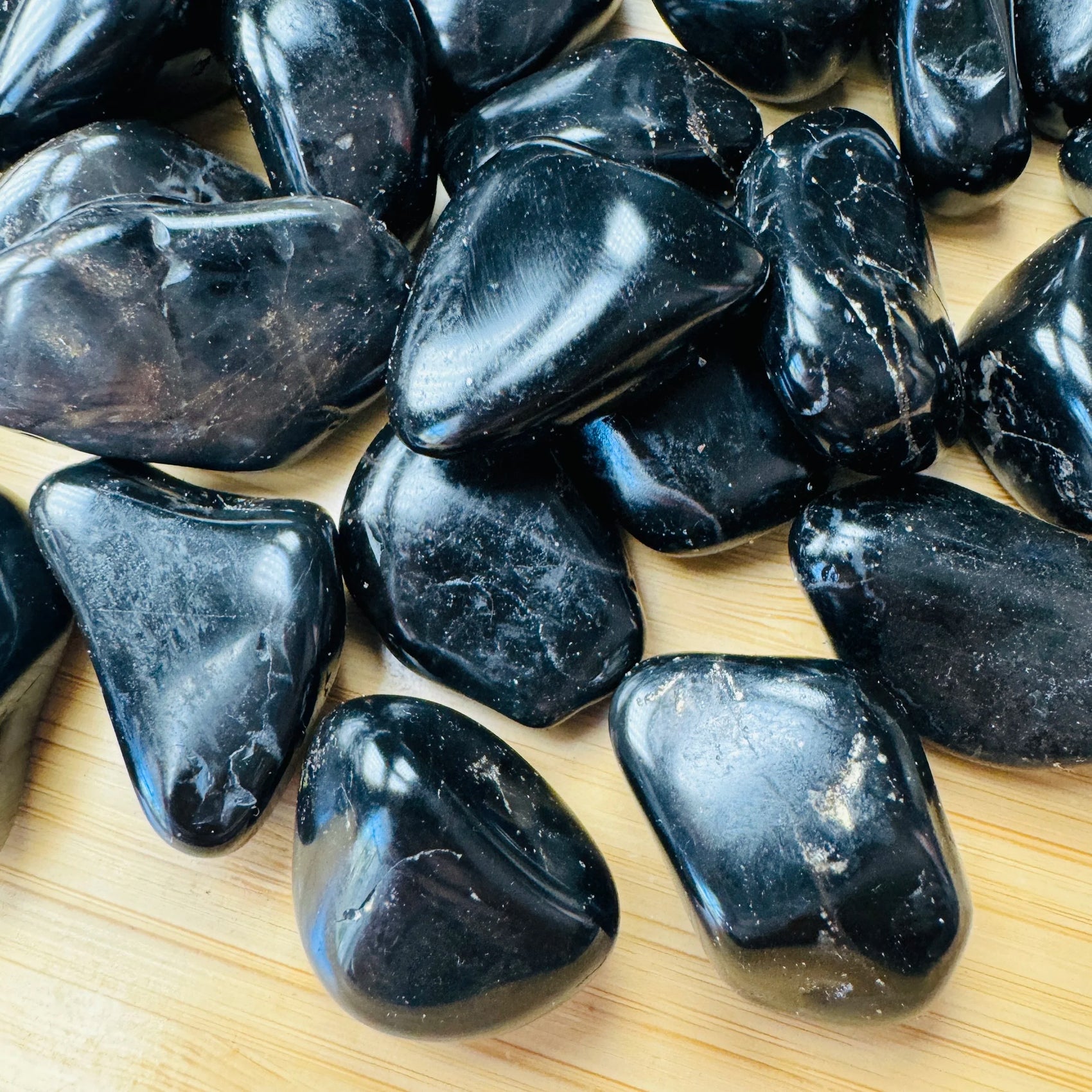 Up-close view of Grade AA Black Onyx tumbled stone, from Brazil, showing subtle veining.