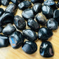 Close-up of Black Onyx tumbled stone from Brazil, soothing wellness stone for Protection
