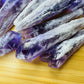 Hand-scale shot of a Amethyst raw point held against natural backdrop, sourced from Bahia, Brazil.