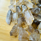 Profile view of Smoky Quartz raw point, showing natural sheen.