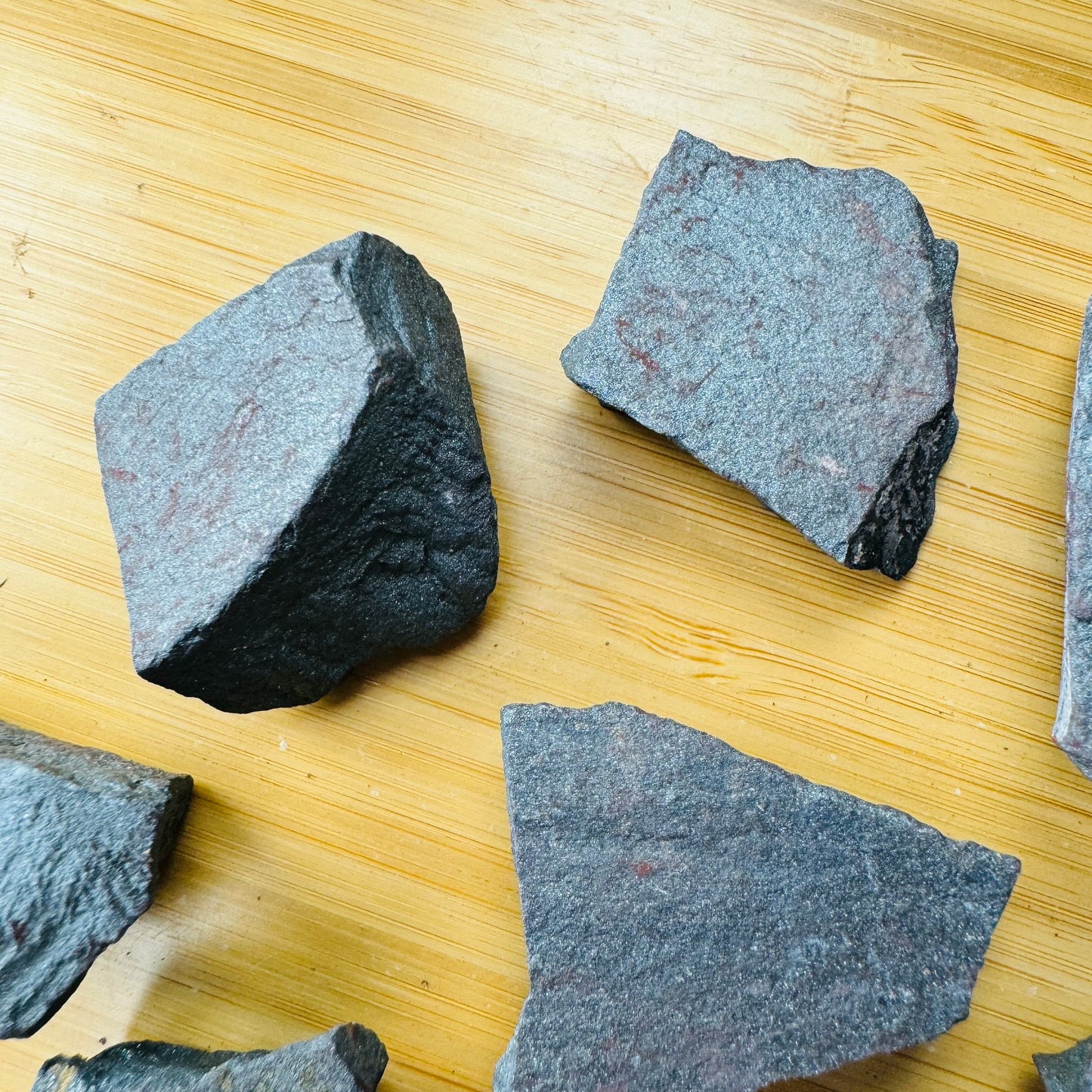 Bird's-eye view of gray Hematite raw stone, often kept for Grounding and Protection, showing characteristic finish.