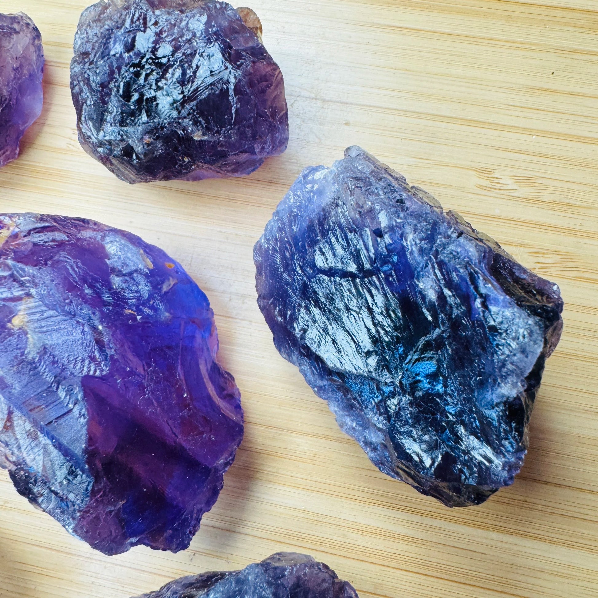 Lifestyle view of a Amethyst raw stone held against natural backdrop, hand-selected from Rio Grande do Sul, Brazil.