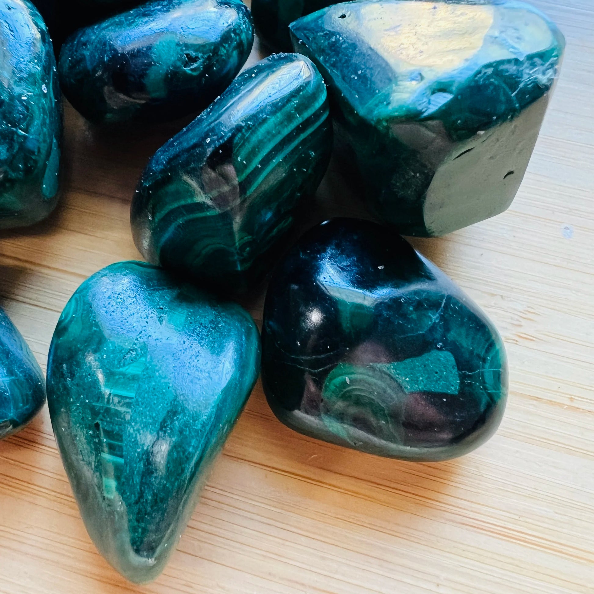 Reverse angle of green Malachite tumbled stone, showing matte finish, often worked with for Emotional Healing.