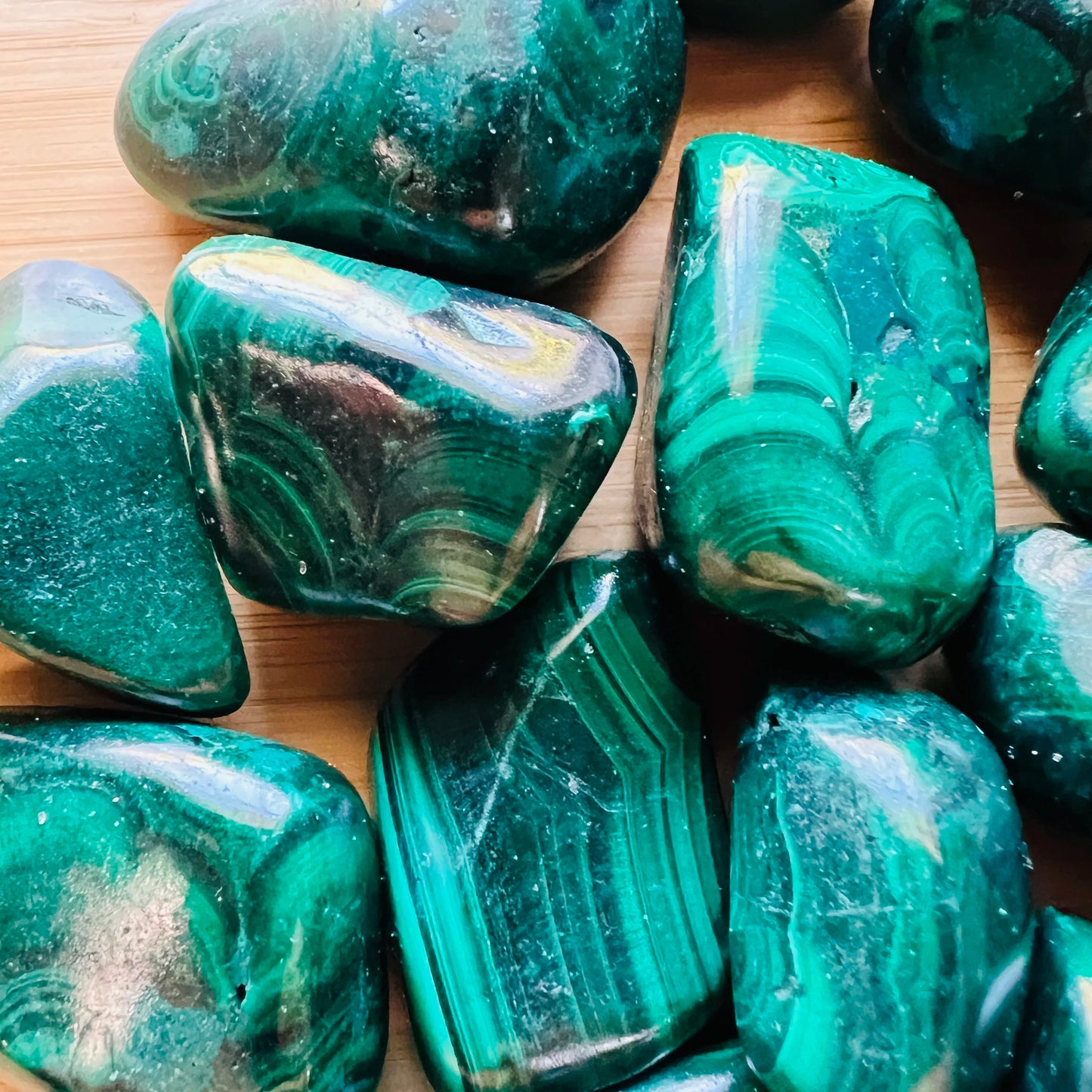 Edge view of Malachite tumbled stone, kept near for Emotional Healing and Protection.