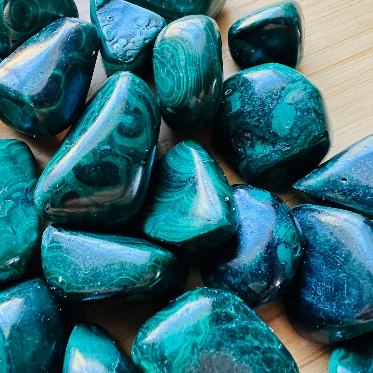 Size comparison with a Malachite tumbled stone, sourced from Haut-Katanga, Democratic Republic of the Congo.