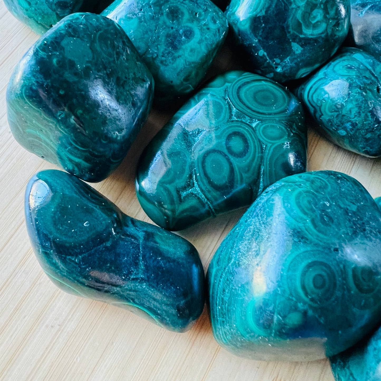 Sideways view of Malachite tumbled stone, showing characteristic finish.