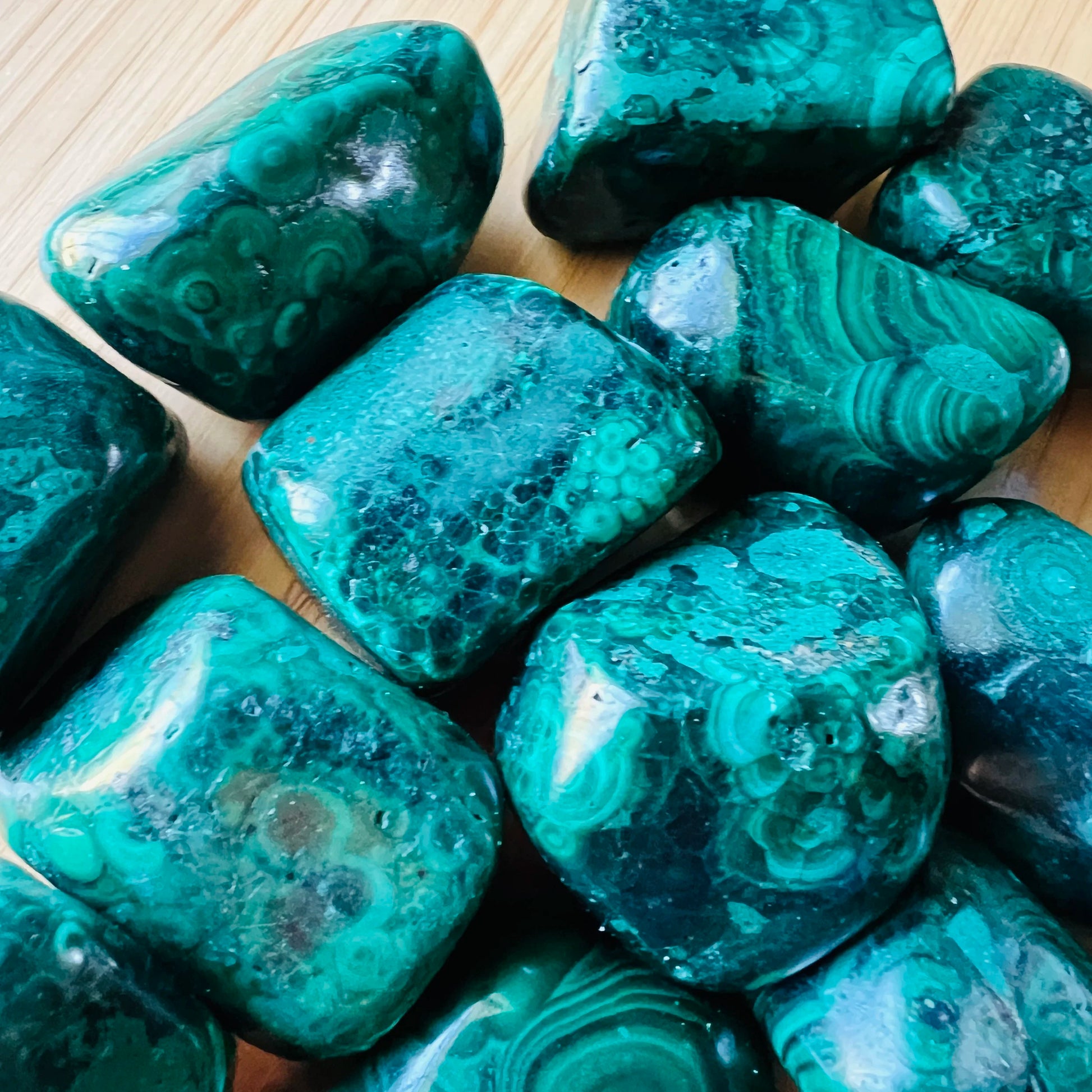Overhead angle of Malachite tumbled stone, carried for Emotional Healing, from Haut-Katanga, Democratic Republic of the Congo.