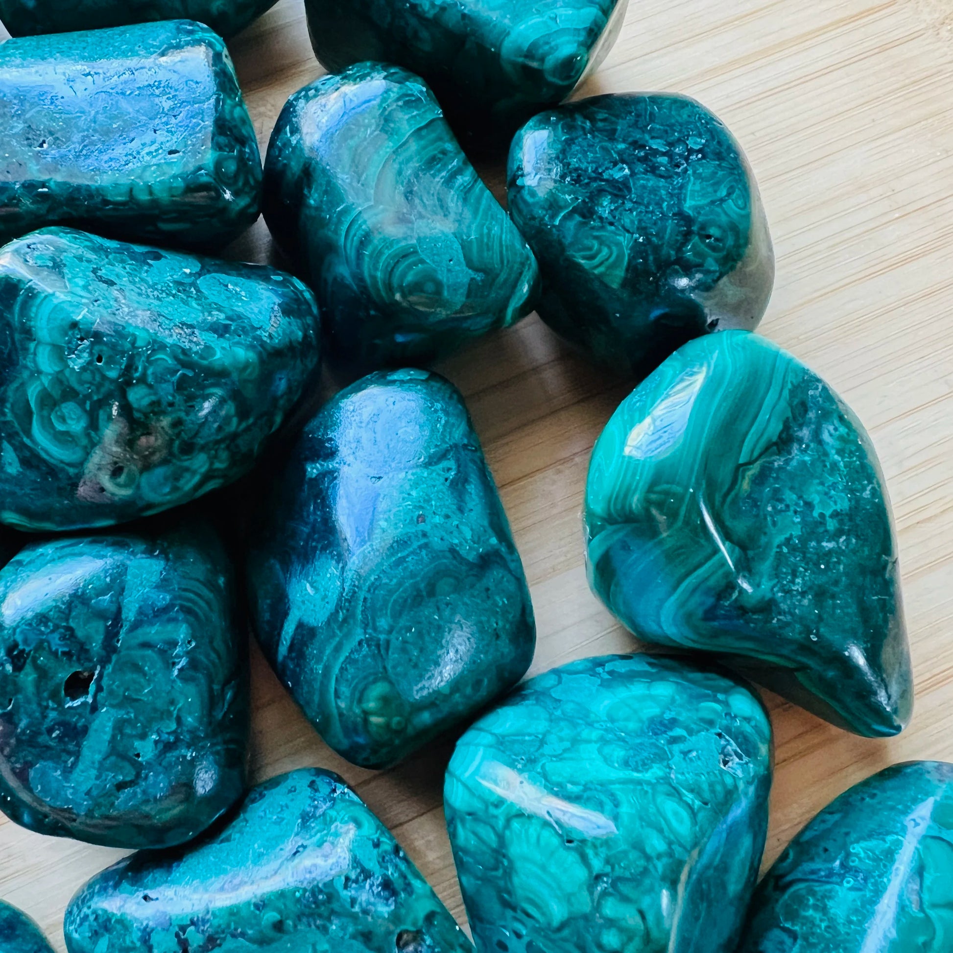 Bottom side of Malachite tumbled stone, showing characteristic patterning.