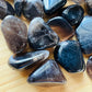 Macro view of Smoky Quartz tumbled stone, sourced from Vakinankaratra, Madagascar, traditionally used for Grounding.