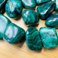 Reverse side of Malachite tumbled stone, showing soft luster.