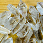 Side-on view of clear Lemurian Quartz raw point, showing characteristic finish.