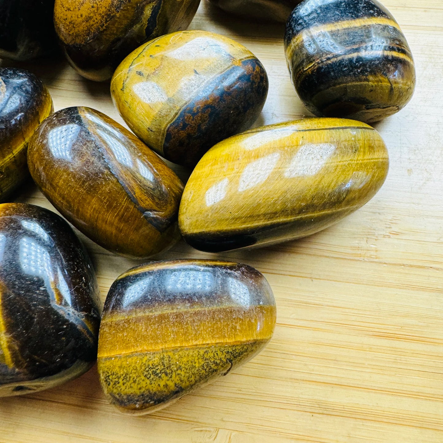 Side-on view of Grade AA Tiger Eye tumbled stone, hand-selected from Northern Cape, South Africa.