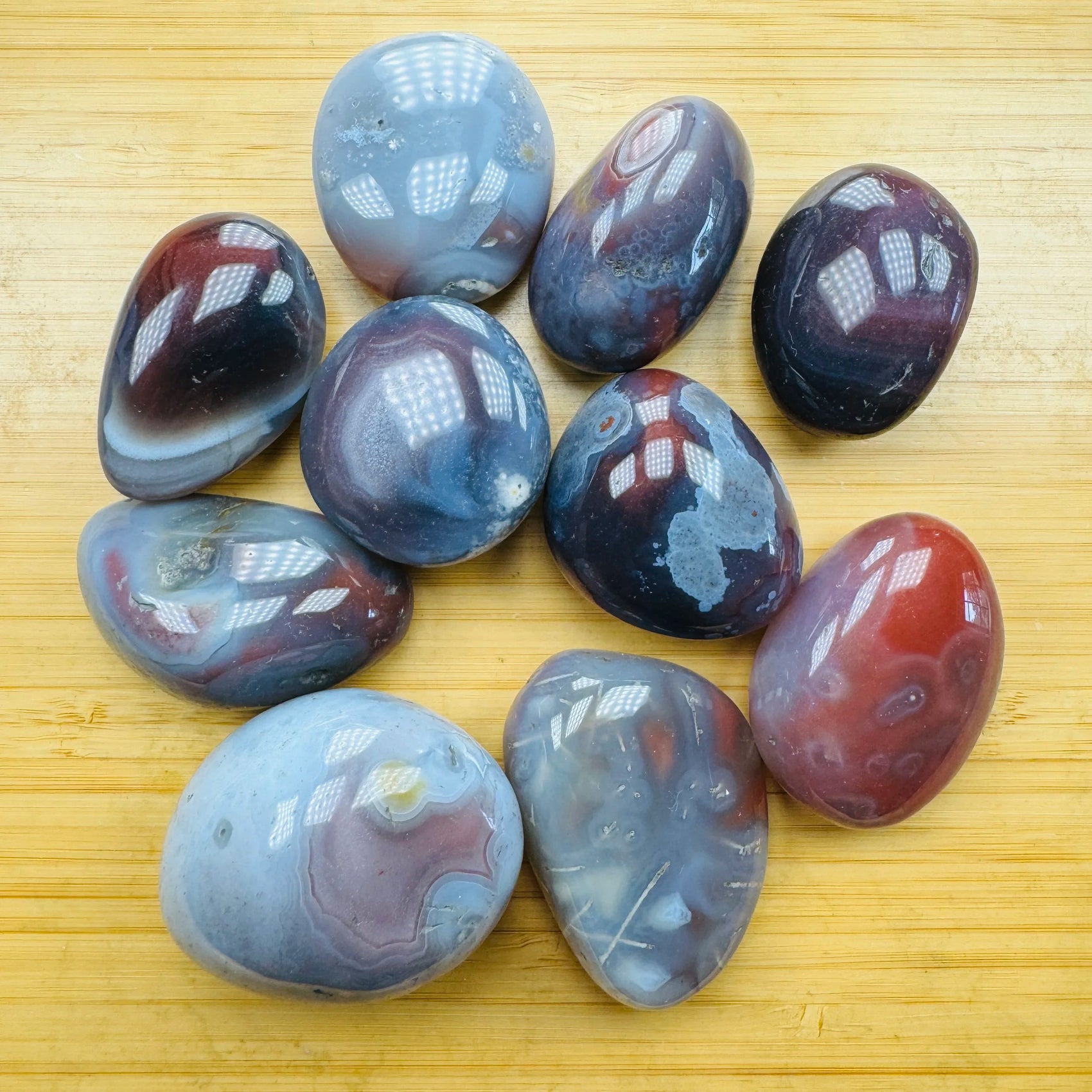 Quiet study of Red Agate tumbled stone, captured against a quiet backdrop.