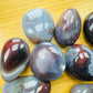 Detail shot of Grade AA Red Agate tumbled stone under natural light