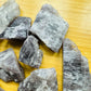 Grade aa anhydrite raw held in hand for size reference