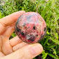 Scale comparison of Rhodonite stone, traditionally used for Love, showing natural surface character.