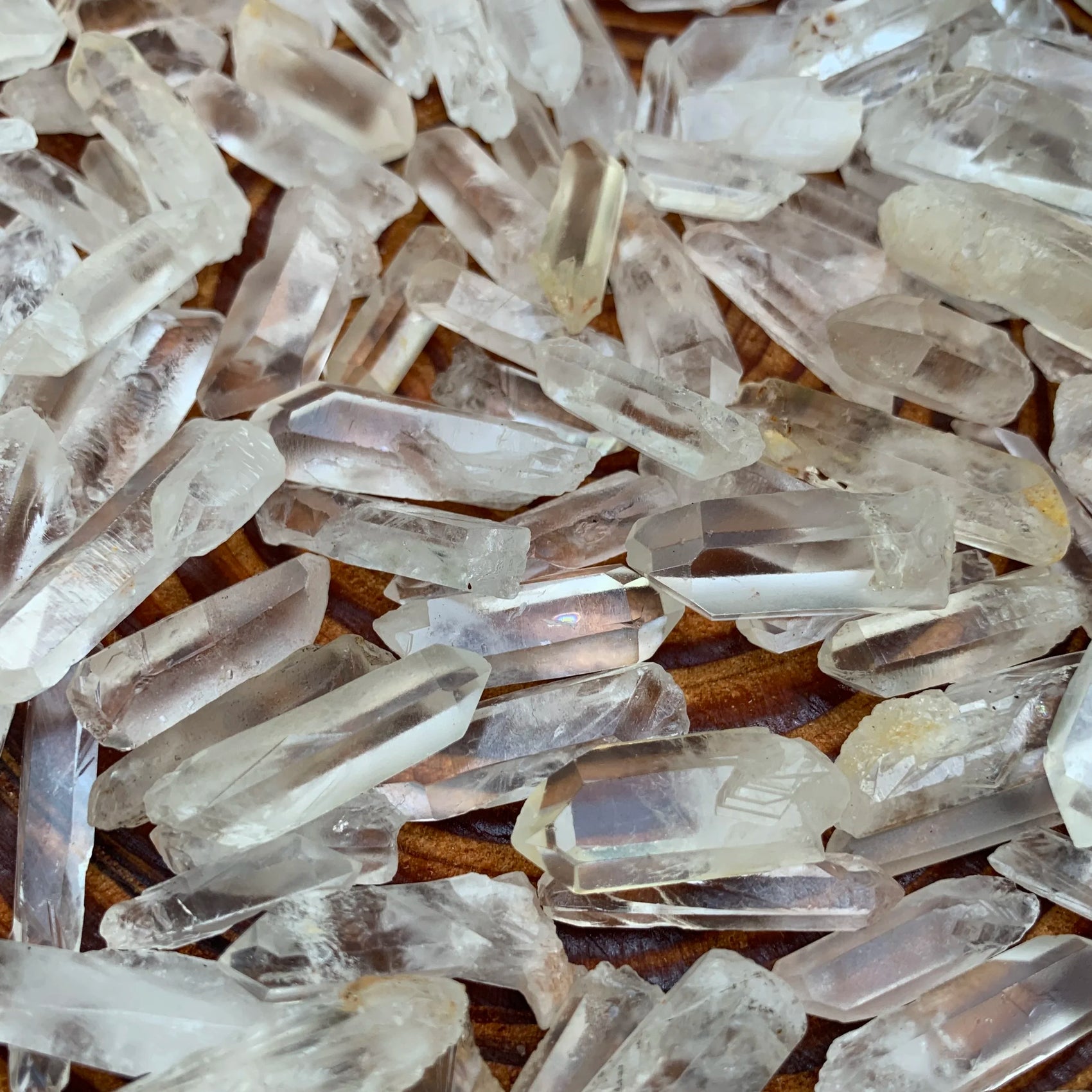 Grade a clear quartz point held in hand for size reference
