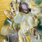 Side-on view of Lodolite tumbled stone, showing soft luster.