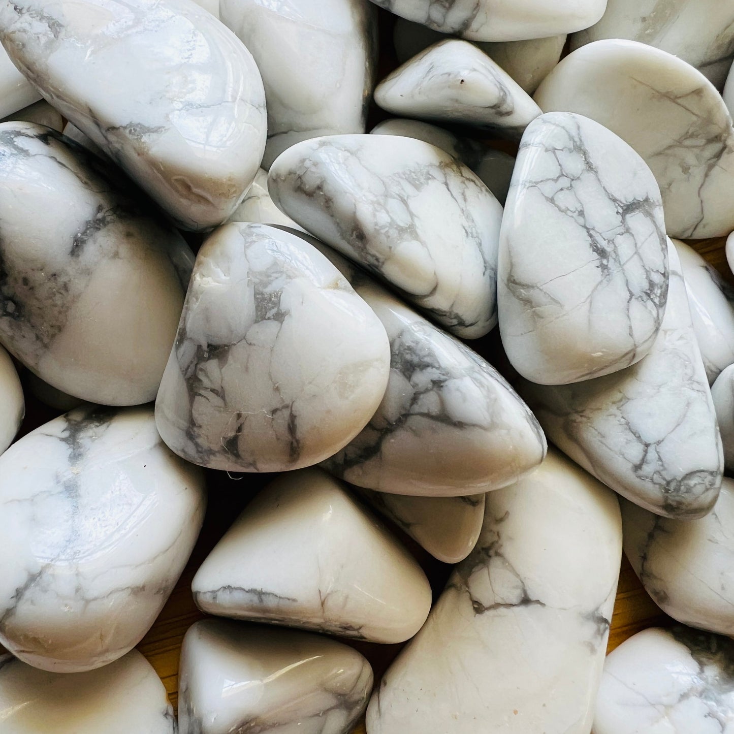 Sideways view of Howlite tumbled stone, showing soft luster.