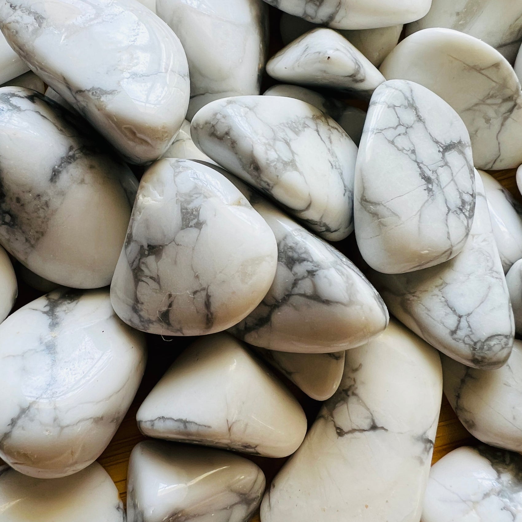 Sideways view of Howlite tumbled stone, showing soft luster.