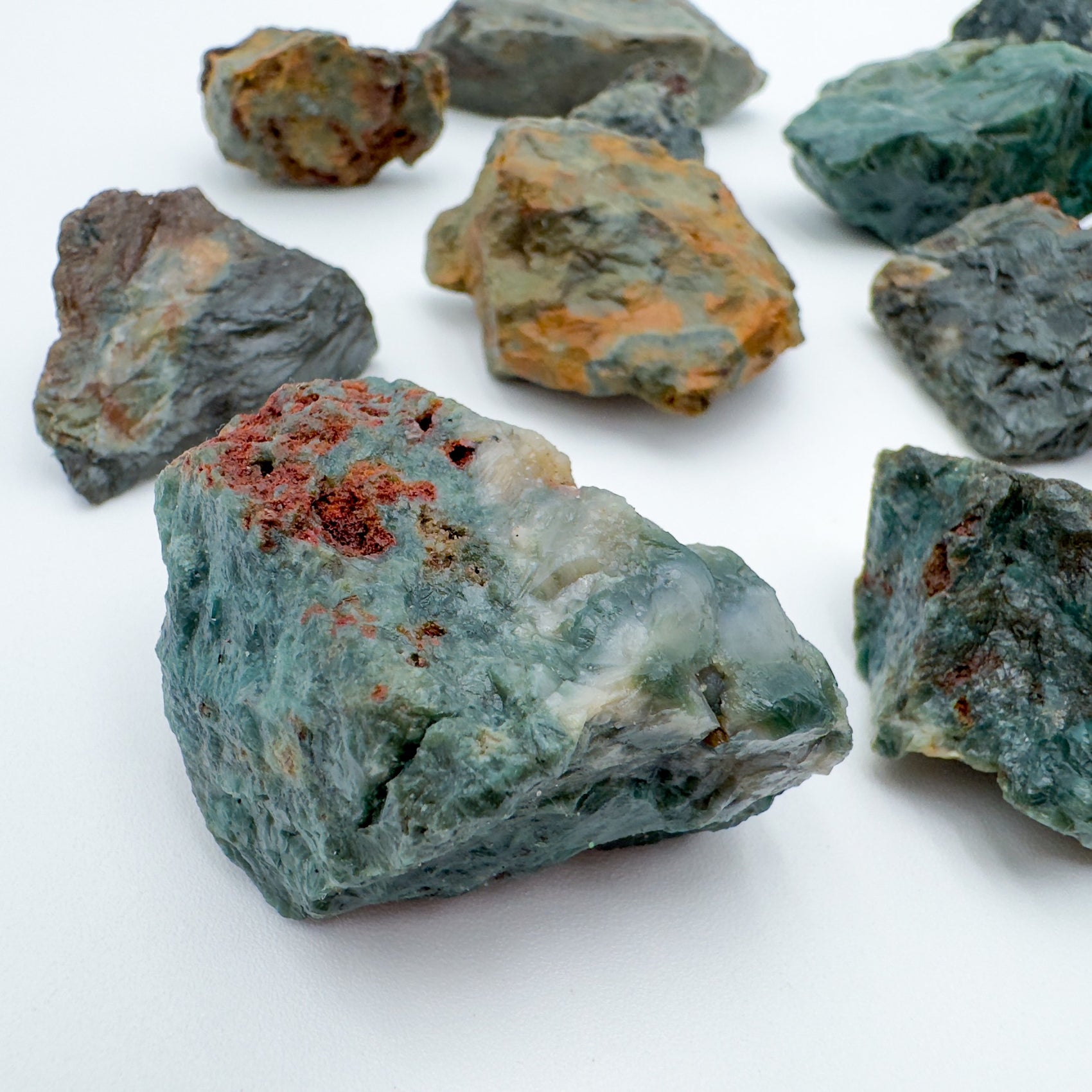 Sideways view of green Ocean Jasper raw stone, from Madagascar, showing natural inclusions.