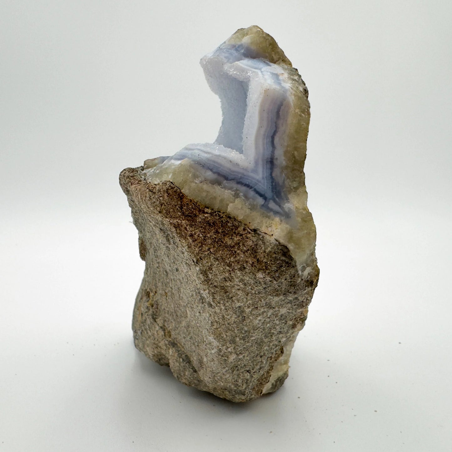 Hand-held view of a single Blue Lace Agate raw geode sourced from Malawi.