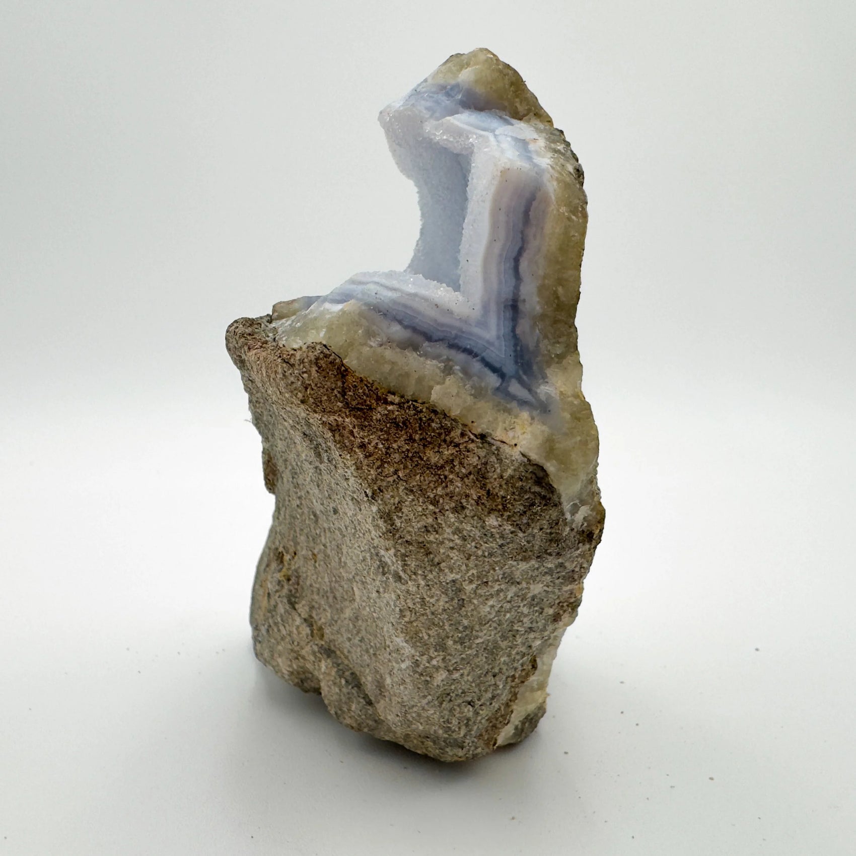Hand-held view of a single Blue Lace Agate raw geode sourced from Malawi.