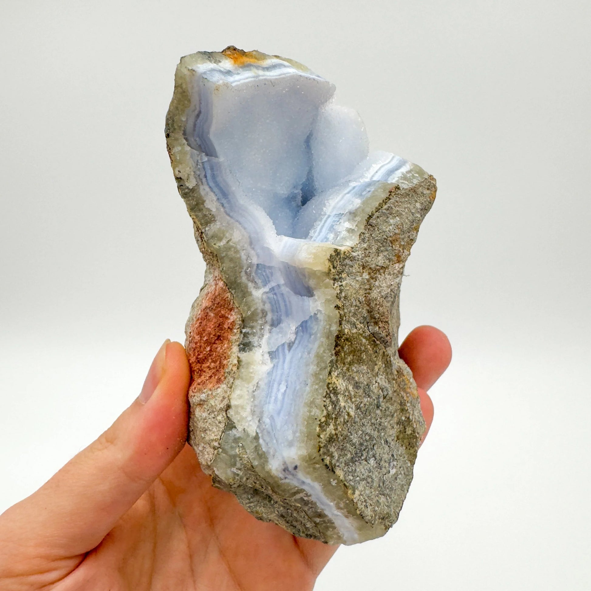 Grade aa blue lace agate geode held in hand for size reference