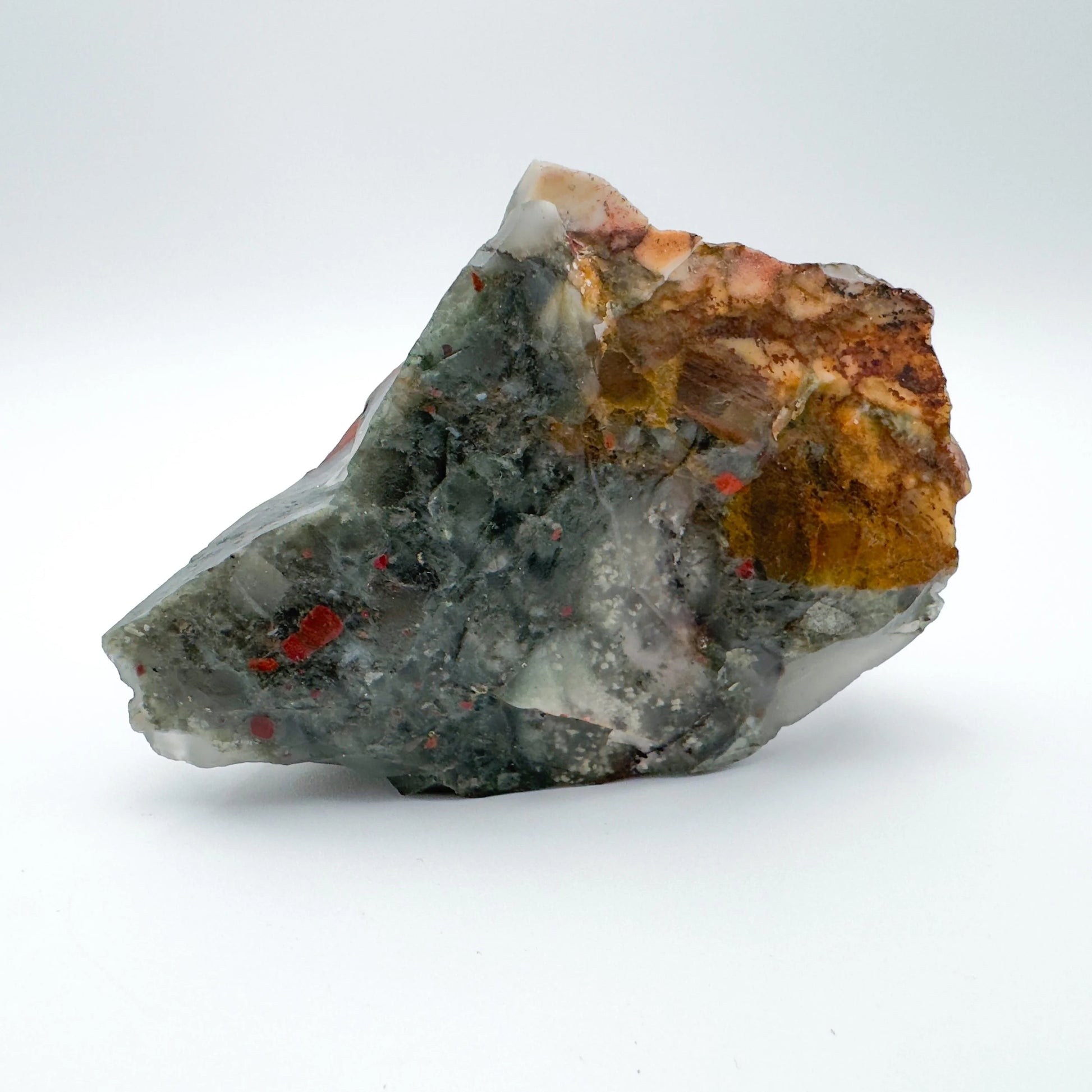 Daylight view of a Bloodstone specimen held against natural backdrop, from Hhohho, Eswatini.