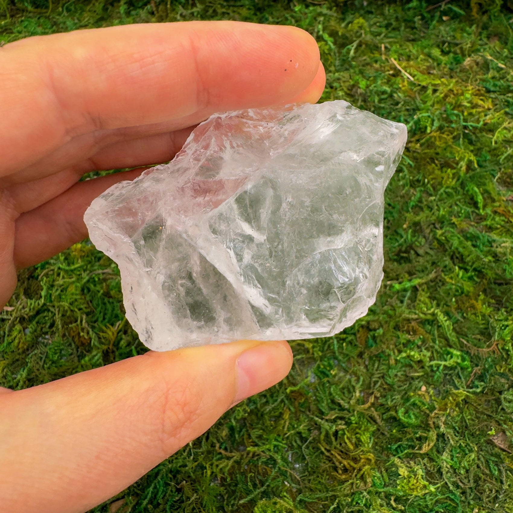 In-hand view of a single Clear Quartz raw stone sourced from Brazil.