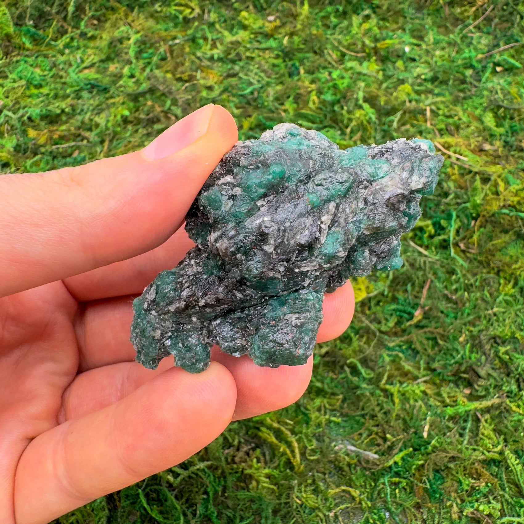Hand-held view of one Emerald raw stone for scale, Zimbabwe-sourced, from Zimbabwe.