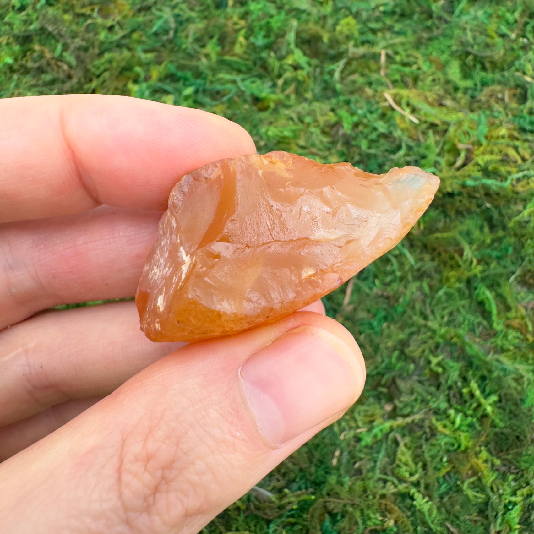 Grade a carnelian raw held in hand for size reference