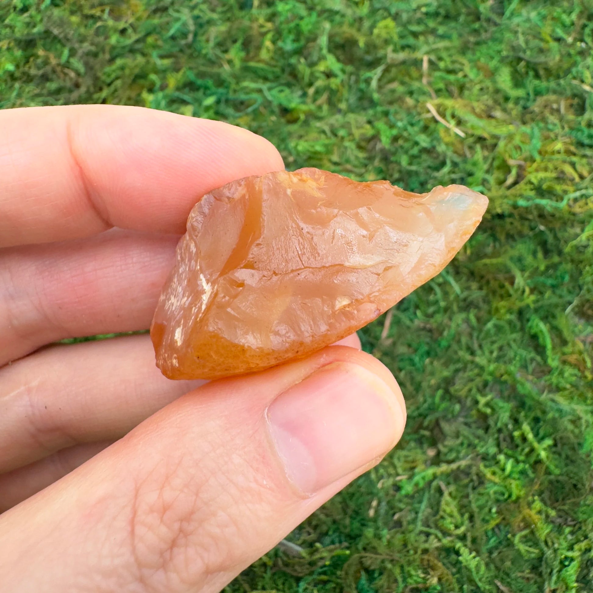 Grade a carnelian raw held in hand for size reference