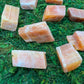 Back view of Grade AA Orange Calcite raw showing natural surface