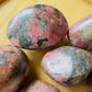 Near view of Rhodonite freeform, sourced from Zimbabwe, showing natural texture.