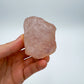 Held in hand is a Rose Quartz specimen, from Alaotra-Mangoro, Madagascar, captured in soft, even lighting.