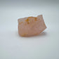 Composed shot of Rose Quartz specimen, traditionally used for Stress Relief, with weight visible in the palm.