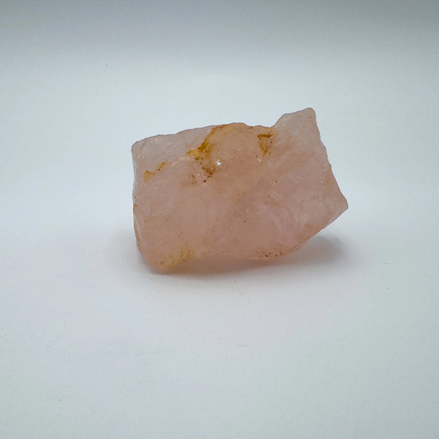 Composed shot of Rose Quartz specimen, traditionally used for Stress Relief, with weight visible in the palm.