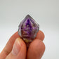 Hand-held view of a Smoky Amethyst raw point kept near for Grounding and Stress Relief.
