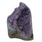 AA grade amethyst geode from Uruguay, angled three-quarter view, a thick olive-brown basalt base with teal celadonite banding, specimen 41.