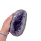 Amethyst polished geode from Uruguay held in an open hand, showing true scale, 5.39 pound closed almond-shaped nodule, specimen 11.