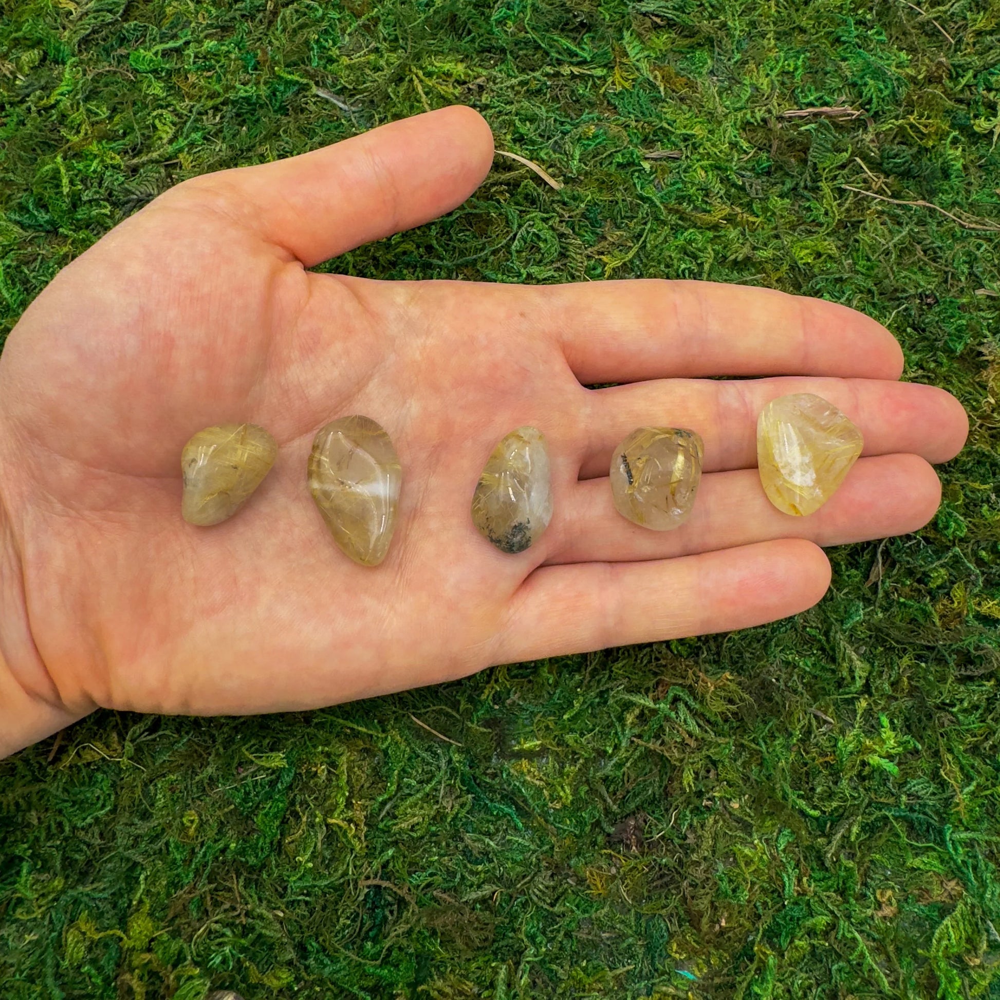 Lifestyle view of a single Quartz tumbled stone sourced from Brazil.