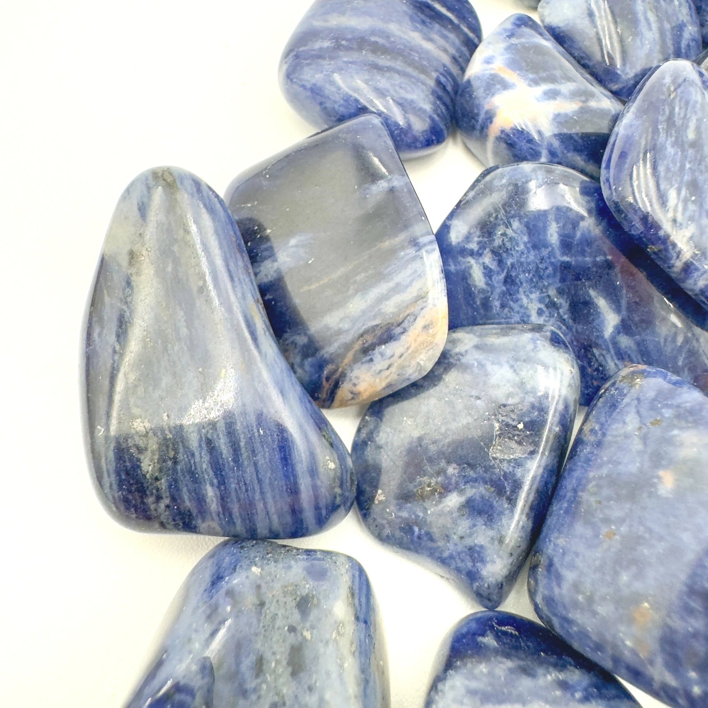 Reverse angle of Sodalite tumbled stone, sourced from Kunene, Namibia, showing characteristic color.