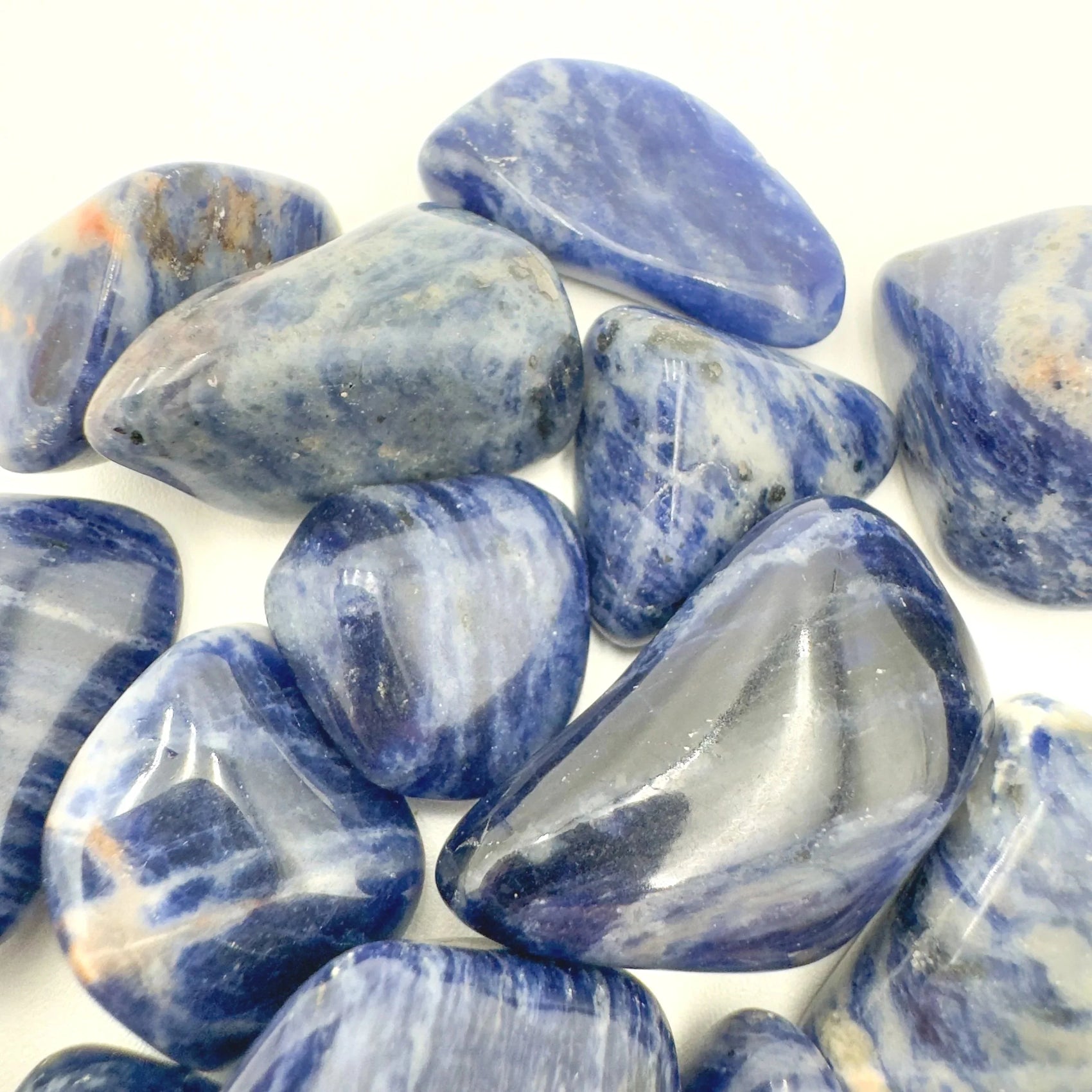 Tabletop view of Sodalite tumbled stone, from Kunene, Namibia, often kept for Meditation, with natural details visible.