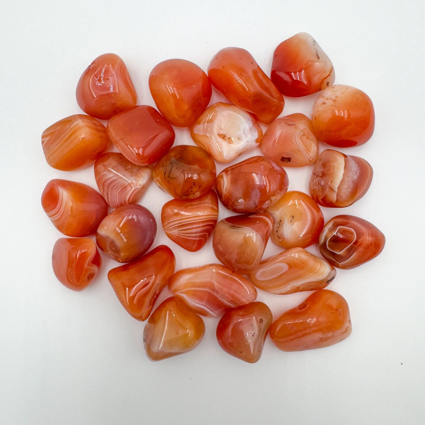 Close-up detail of Grade AA Carnelian tumbled stone showing natural orange, red tones and texture