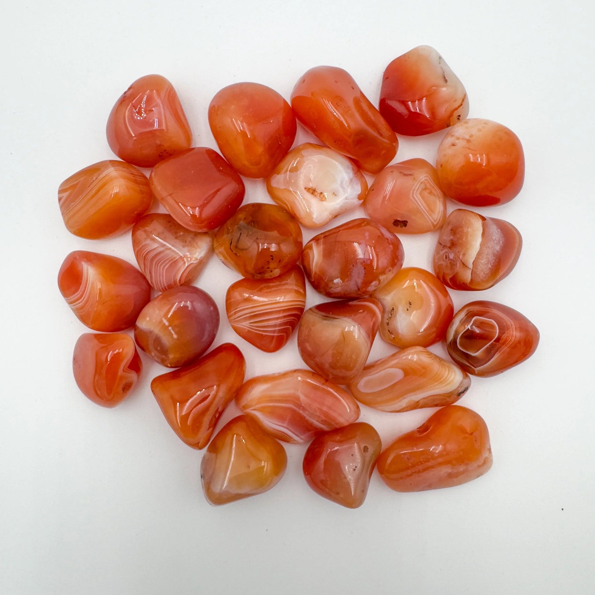 Close-up detail of Grade AA Carnelian tumbled stone showing natural orange, red tones and texture