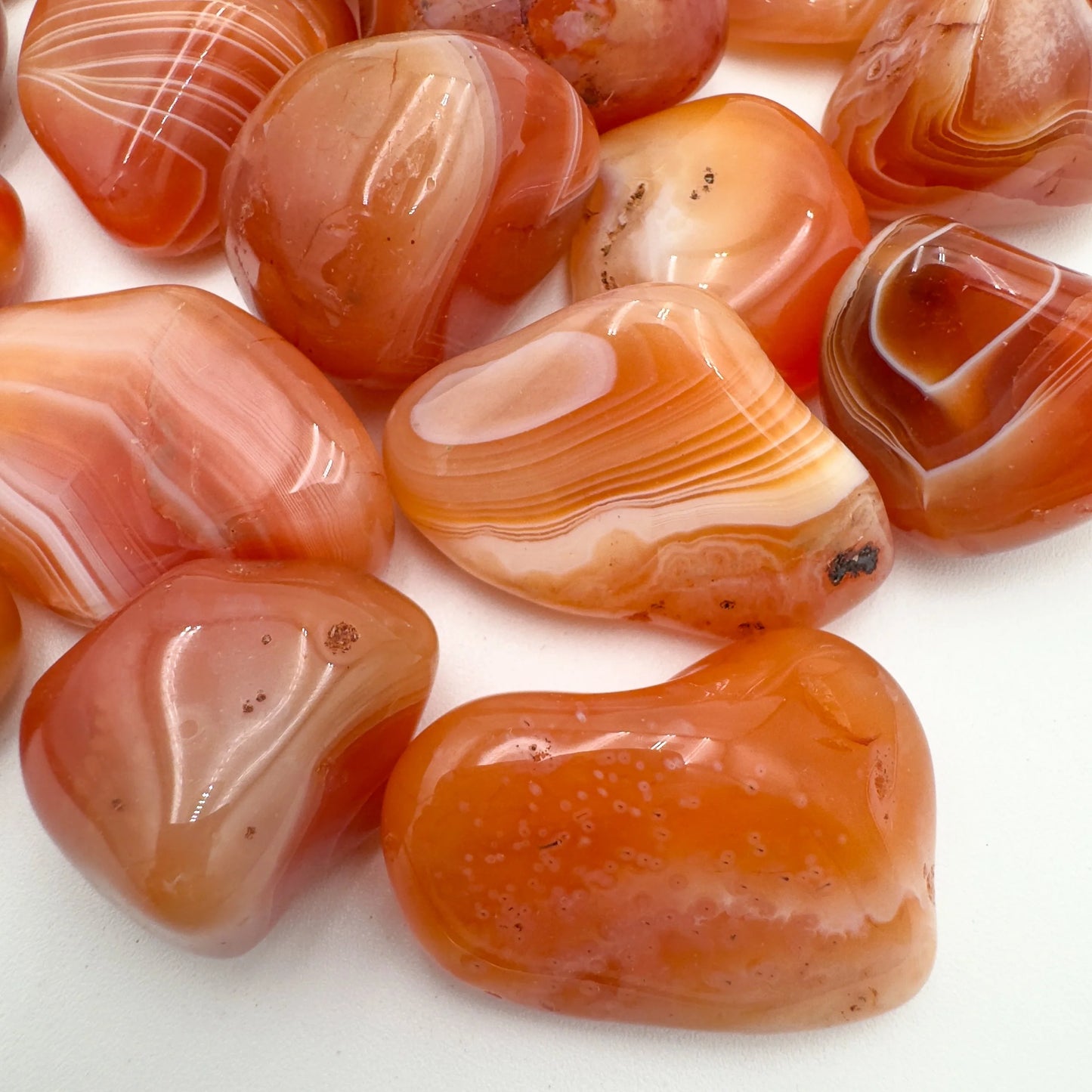 Side profile of Grade AA Carnelian tumbled stone with natural form and inclusions
