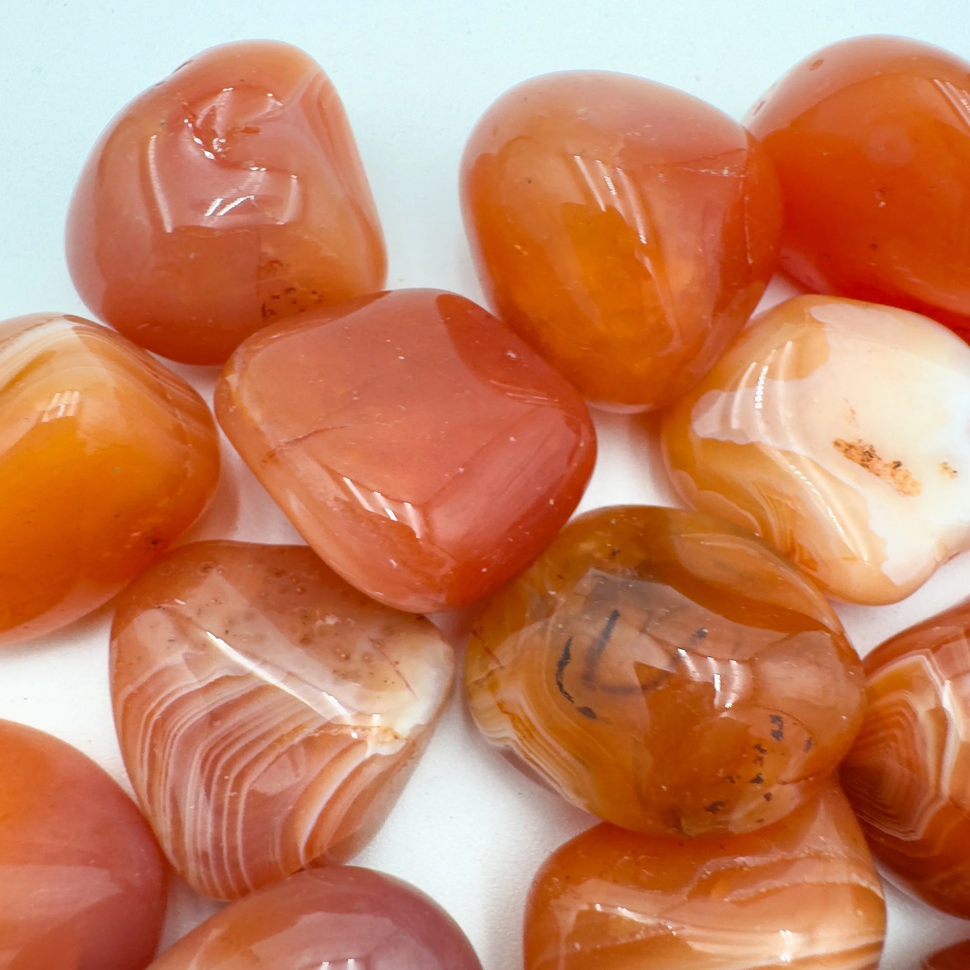 Grade aa carnelian tumbled stone held in hand for size reference