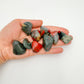 Detail shot of Grade AA Bloodstone tumbled stone under natural light