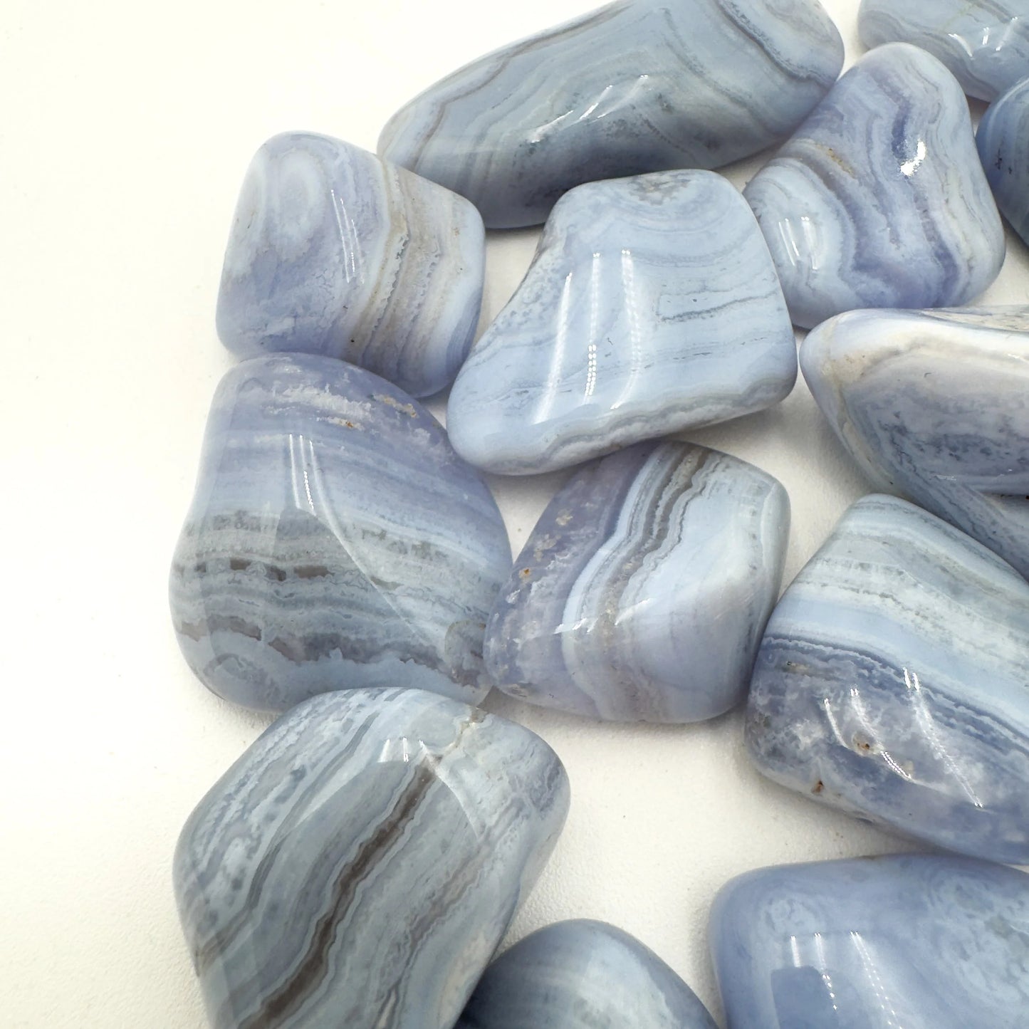 Edge-on view of Grade A Blue Lace Agate tumbled stone, from Namibia, showing characteristic color.